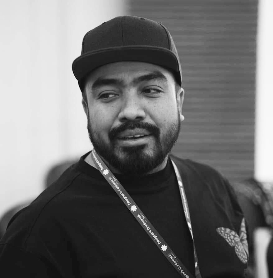 A man sitting on a stool in a black shirt.